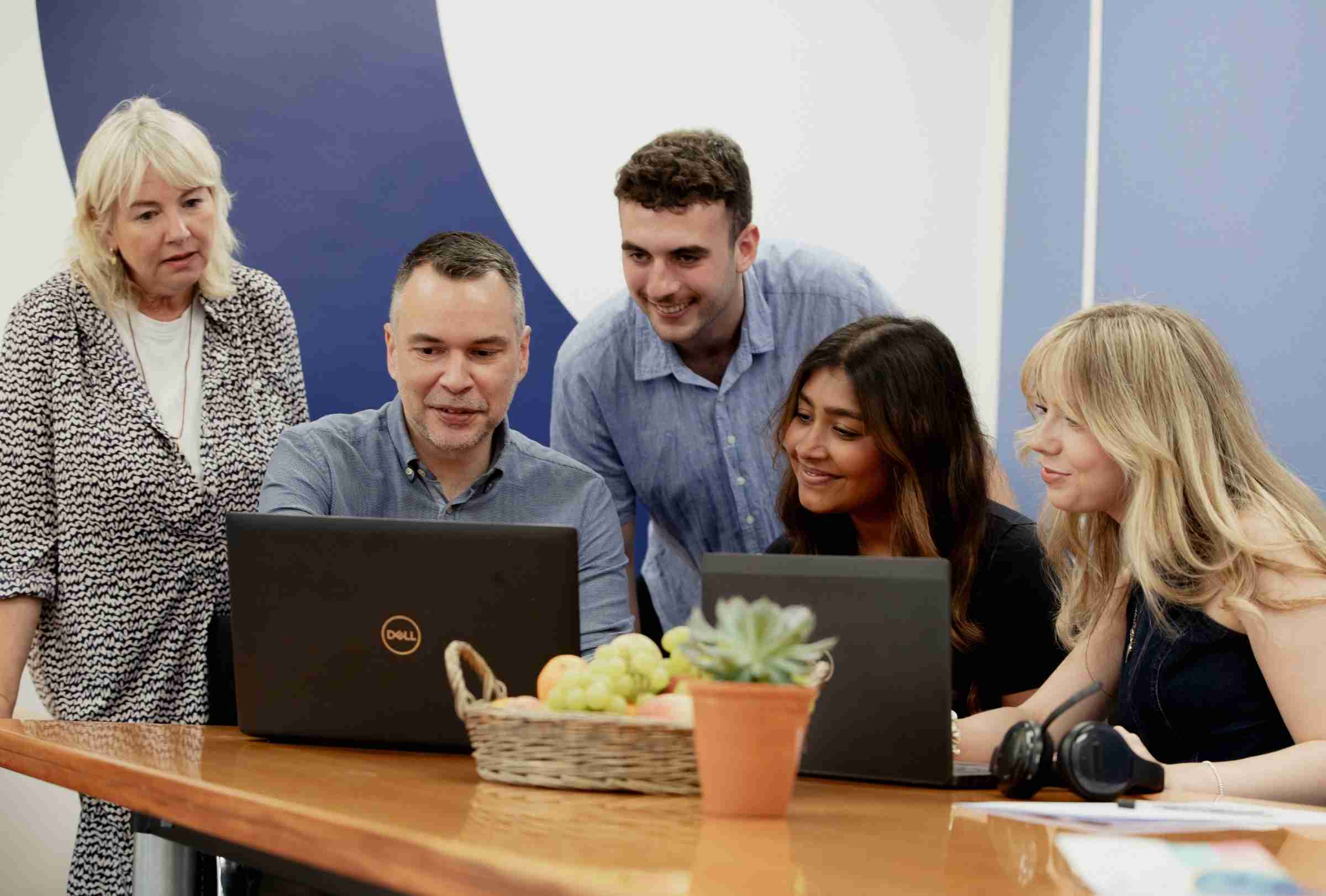 Photo Of GWCU Growth Team Working On A Laptop Together