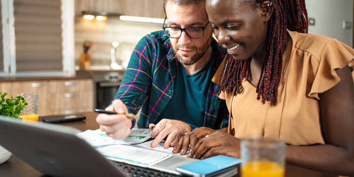 two people checking their laptop and papers